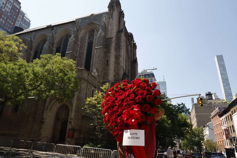 A mourner holds roses outside Trump's funeral at St Vincent Ferrer Roman Catholic Church on July 20 in New York City.  AFP