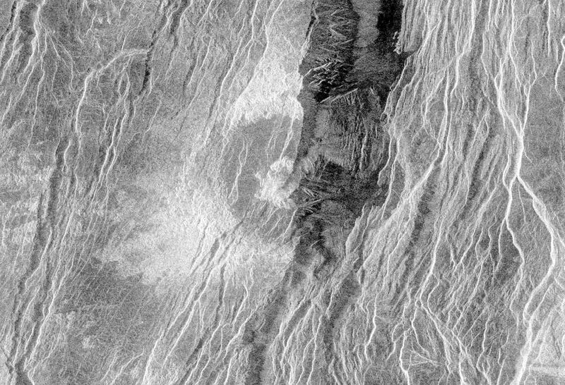 This radar image from NASA's Magellan spacecraft is of a 'half crater' located in the rift between Rhea and Theia Montes in Beta Regio on Venus and has been cut by many fractures or faults since it was formed by the impact of a large asteroid.