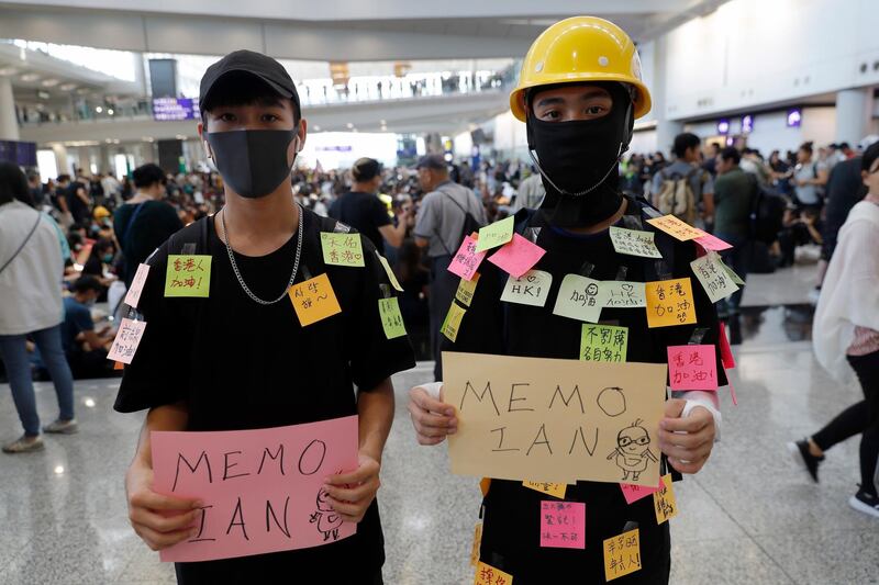Protesters hold banners as they demonstrate at the airport. AP Photo