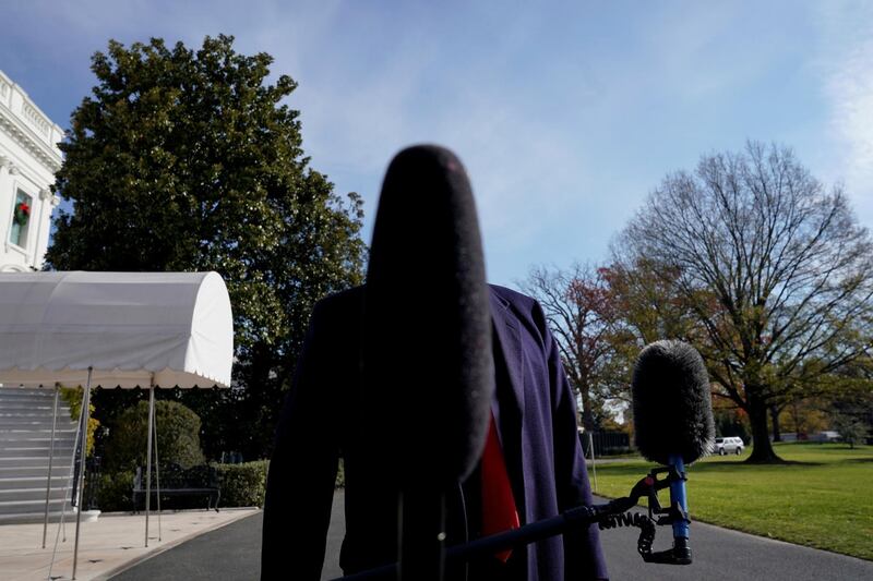 A microphone blocks the face of US President Donald Trump at the White House ahead of his trip to the G20 summit. Reuters