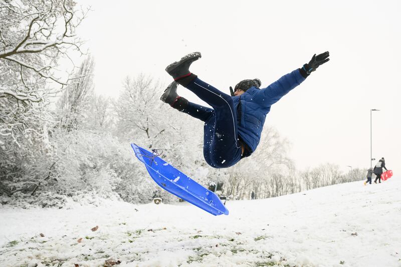 A man takes to the air after hitting a ramp while sledging in Alexandra Palace Park, north London. Getty Images