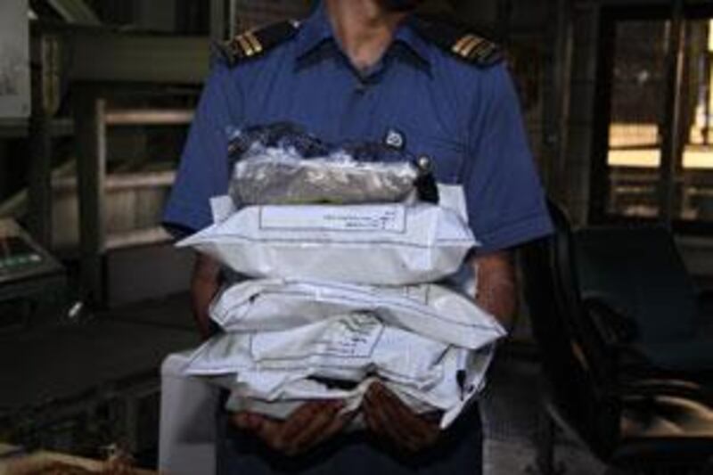 A custom officer at Dubai's Cargo Village poses in May with 11.5kg of raw opium that was hidden inside spools of fabric.