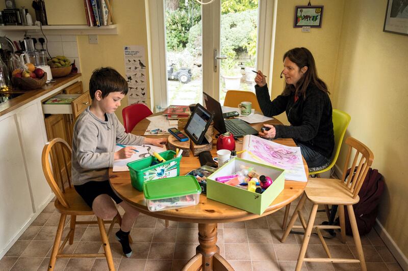 Six-year-old Leo completes a homeschool activity suggested by the online learning website of his infant school, as his mother Moira, an employee of a regional council, works from home in the village of Marsden, near Huddersfield, northern England on May 15, 2020, during the novel coronavirus COVID-19 pandemic. - Prime Minister Boris Johnson has urged millions unable to work from home to return to their jobs under the new guidelines, which do not apply in Scotland, Wales or Northern Ireland. (Photo by OLI SCARFF / AFP)