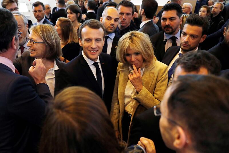 French President Emmanuel Macron (C), flanked by his wife Brigitte Macron (R)and French Culture Minister Francoise Nyssen (L), greets people has he attends the inauguration of the Paris Book Fair in Paris, on March 15, 2018. 
The Paris Book Fair runs until 19 March. / AFP PHOTO / POOL / Etienne LAURENT
