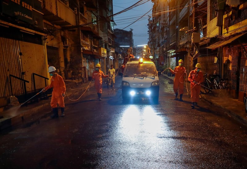 Workers spray disinfectant  in a street at downtown area of Yangon, Myanmar.  EPA