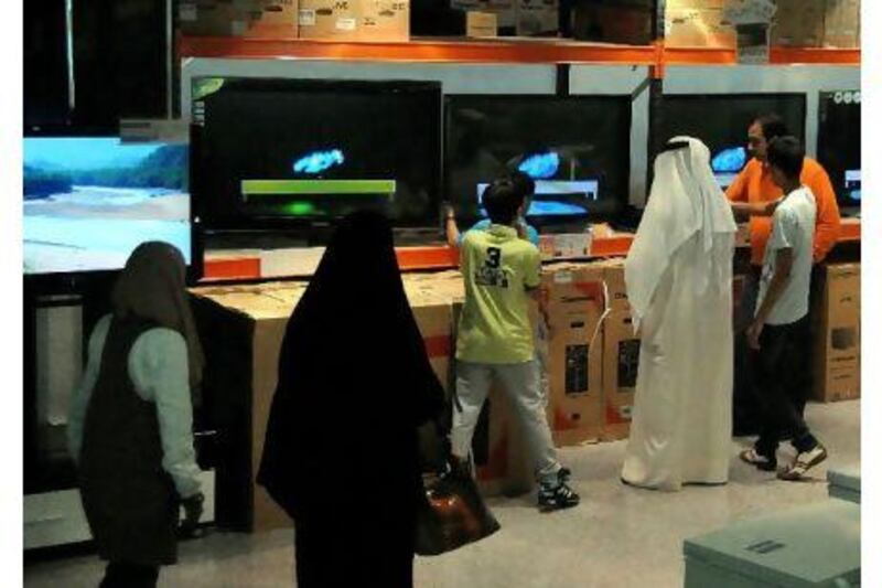 A family spends a portion of their grant from the emir on Wednesday at an electronics store in Salmiya, Kuwait.