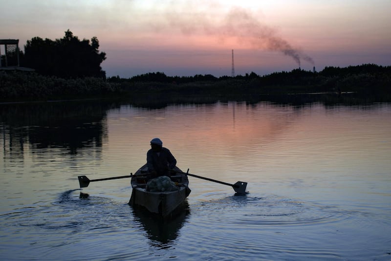 A man sails on the Euphrates river at sunset in the Iraqi city of Nasiriyah in the Dhi Qar province, about 360 kms southeast of the capital Baghdad , on December 30, 2020. (Photo by Asaad NIAZI / AFP)