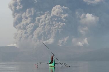 A youngster living at the foot of Taal volcano rides an outrigger canoe away from danger near Tanauan, south of Manila. Courtesy:AFP