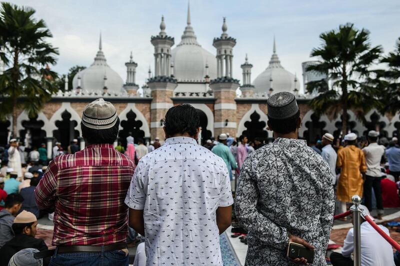 Muslims wait for Eid al Fitr prayers at the Jamek Mosque in Kuala Lumpur. Mohd Rasfan / AFP