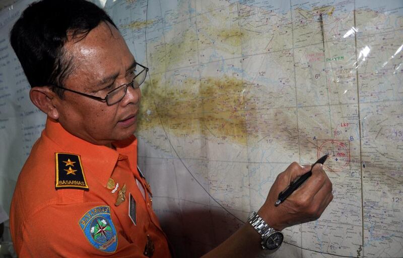 An Indonesian rescue officer points to the coordinates where the missing Trigana Air plane is believed to have crashed on a map, in Jayapura, Indonesia. EPA