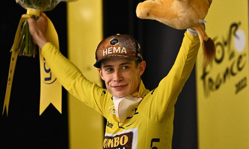 Jumbo-Visma team's Danish rider Jonas Vingegaard celebrates on the podium with the overall leader's yellow jersey. AFP