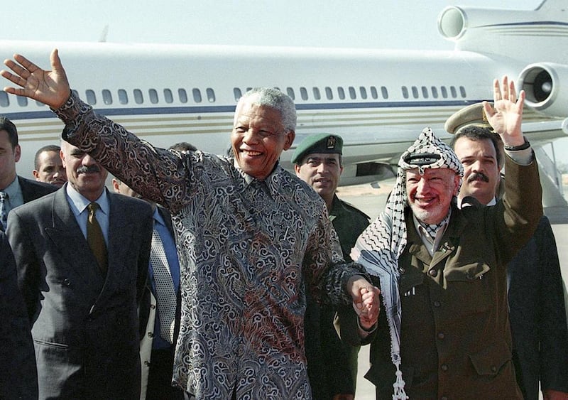 October 19, 1999: Palestinian Authority president Yasser Arafat and the former president of South Africa Nelson Mandela wave to a cheering crowd during their meeting at Gaza international airport. AFP Photo