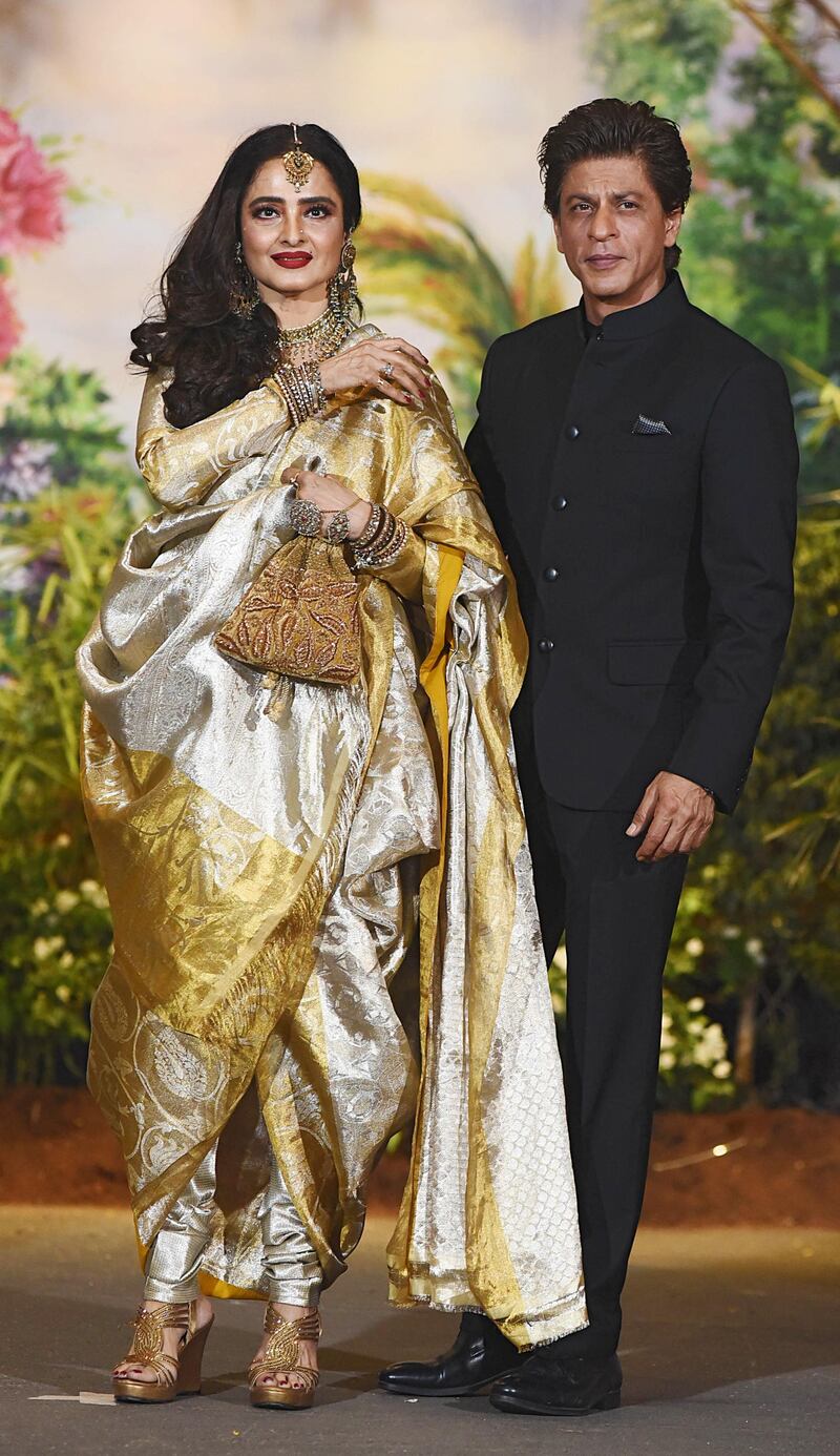 Legendary actors Rekha (L) and Shah Rukh Khan pose for a picture during the wedding reception of actress Sonam Kapoor and businessman Anand Ahuja in Mumbai late on May 8, 2018. / AFP PHOTO / Sujit Jaiswal