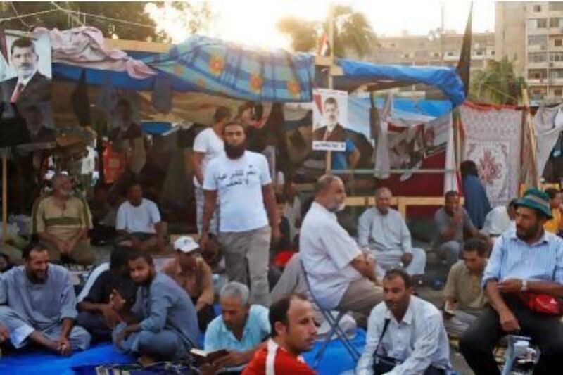 Supporters of deposed Egyptian President Mohammed Morsi sit near tents in their protest area around Raba' al-Adawya mosque, east of Cairo. The Muslim Brotherhood-organised protests call for Mr Morsi’s reinstatement.