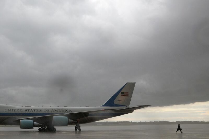 An Air Force One crew member runs towards the base terminal for shelter as a storm approaches following a flight from Maine, at Joint Base Andrews in Maryland, US. Reuters