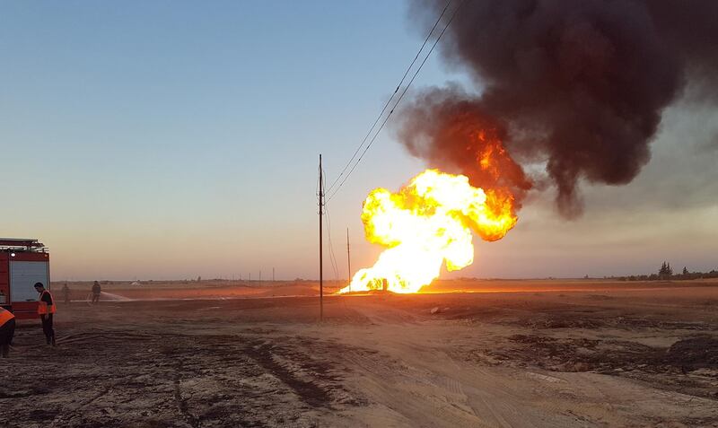 Syrian firefighters extinguish the flames of a gas pipeline that hit by an explosion SANA HO via Reuters