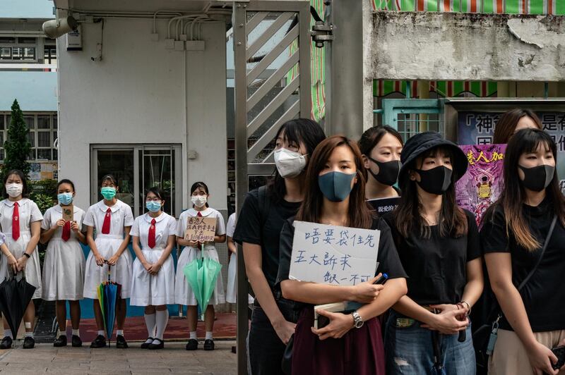 Students and alumni of Kit Sam Lam Bing Yim Secondary School stand as they form a human chain during a protest. Getty Images