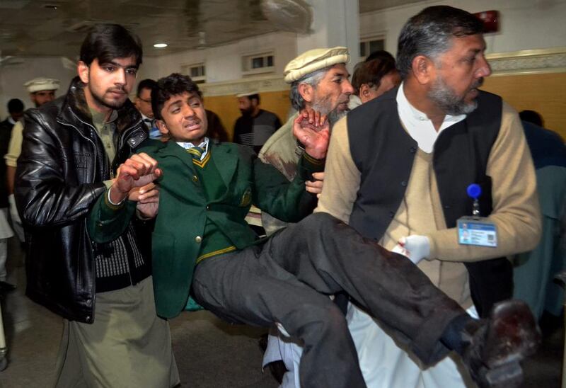 Pakistani volunteers carry a student injured in the shootout at a school under attack by Taliban gunmen, at a local hospital in Peshawar. Mohammad Sajjad / AP Photo