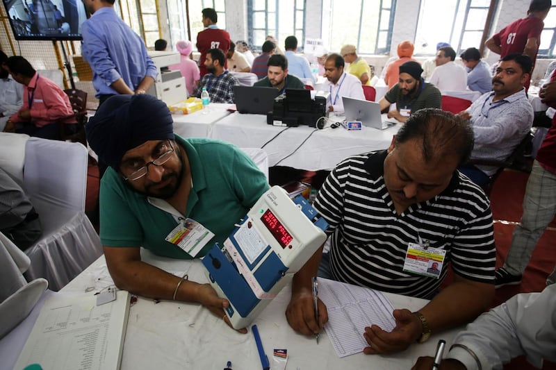 An election official in Jammu display the tally from an electronic voting machine.  EPA