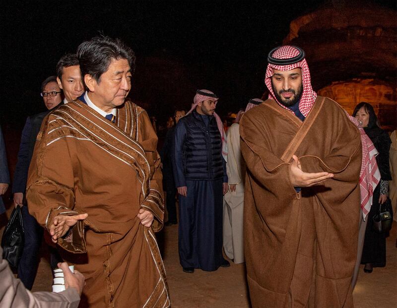 Mr. Abe wears a traditional costume as he walks with Crown Prince Mohammed bin Salman during a meeting in Riyadh.