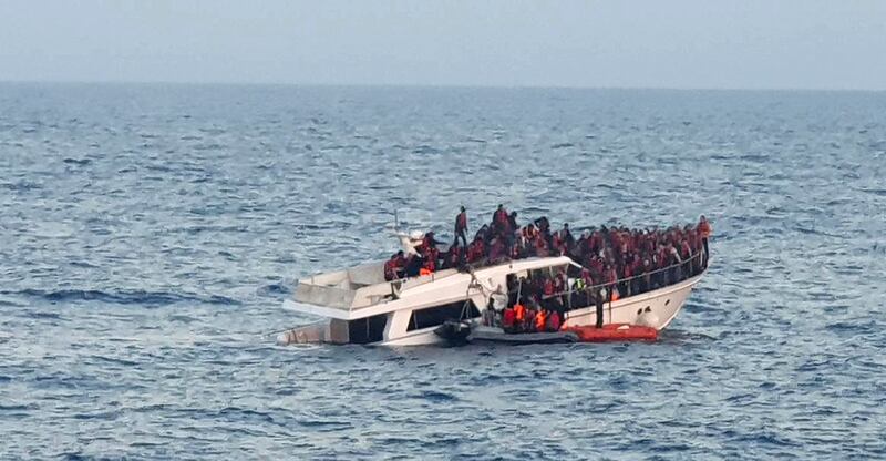 A handout photo provided by the Lebanese Army on December 31, 2022, shows a sinking migrant boat in Mediterranean waters, off the country's northern coast near Tripoli during a rescue operation by the Lebanese navy. Photo by Lebanese Army Website/AFP