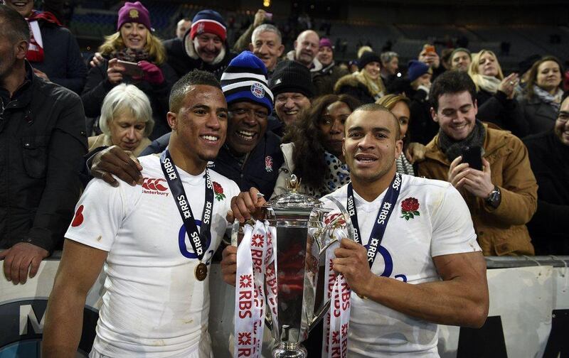 England’s winger Anthony Watson (L) and England’s centre Jonathan Joseph (R) hold the trophy as they celebrate winning the Six Nations rugby union tournament, after winning their match against France, at the Stade de France in Saint-Denis, north of Paris, on March 19, 2016. AFP PHOTO / FRANCK FIFE