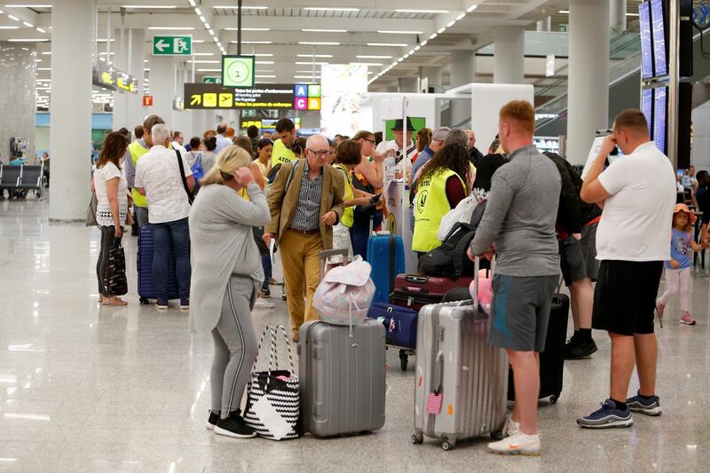 Passengers talk to Civil Aviation Authority employees at Mallorca Airport, in Palma de Mallorca, Spain. Reuters