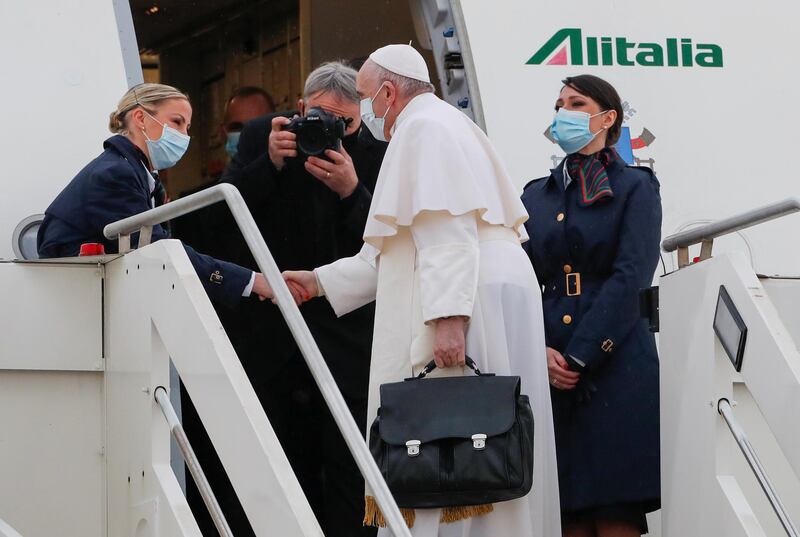 Pope Francis is welcomed by crew members as he boards a plane for his visit to Iraq at Leonardo da Vinci-Fiumicino Airport in Rome, Italy, March 5, 2021. REUTERS/Remo Casilli