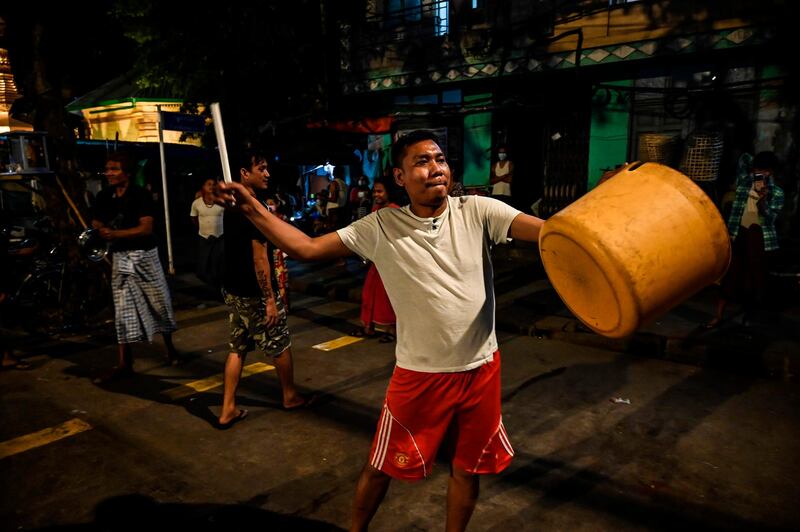 A man hits a plastic container to make noise after calls for protest went out on social media in Yangon, as Myanmar's ousted leader Aung San Suu Kyi was formally charged on Wednesday two days after she was detained in a military coup. AFP