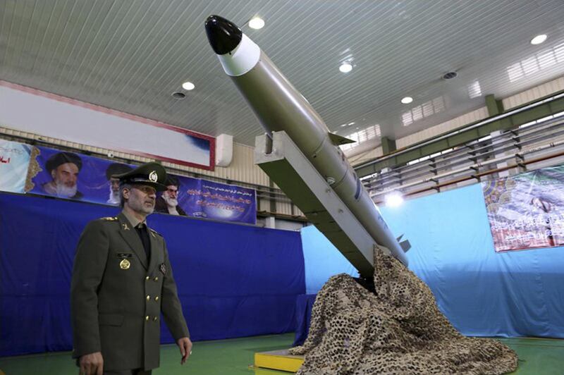 In this picture released by the official website of the Iranian Defense Ministry on Monday, Aug. 13, 2018, Defense Minister Gen. Amir Hatami walks past the missile Fateh-e Mobin, or Bright Conqueror, during inauguration of its production line at an undisclosed location, Iran. Iran on Monday said it launched a production line for a radar-evading, short range surface-to-surface missile capable of hitting targets in any weather condition. (Iranian Defense Ministry via AP)