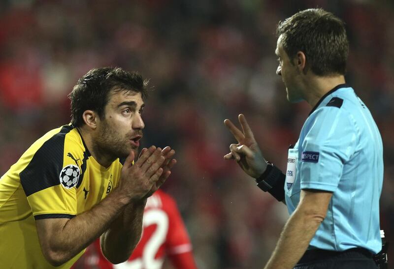 Dortmund's Sokratis Papastathopoulos reacts next to referee Nicola Rizzoli. Armando Franca / AP
