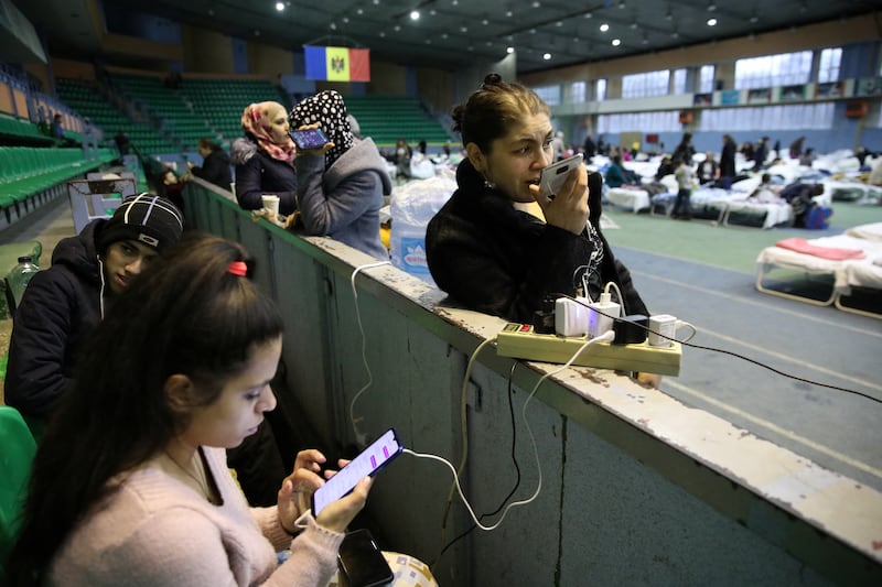 People fleeing Russia's invasion of Ukraine use mobile devices in a temporary refugee centre located at a local track-and-field athletics stadium in Chisinau, Moldova. Reuters