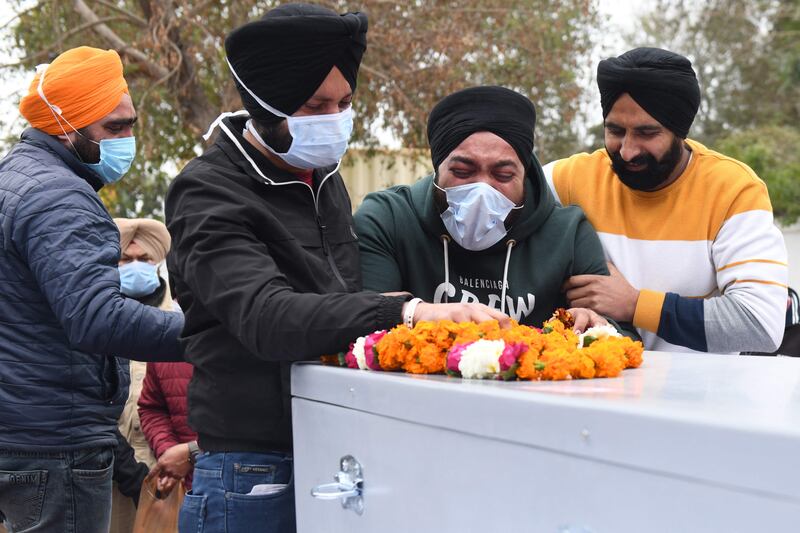 Relatives of Hardeep mourn over the coffin at the Sri Guru Ram Dass Jee International Airport on the outskirts of Amritsar.