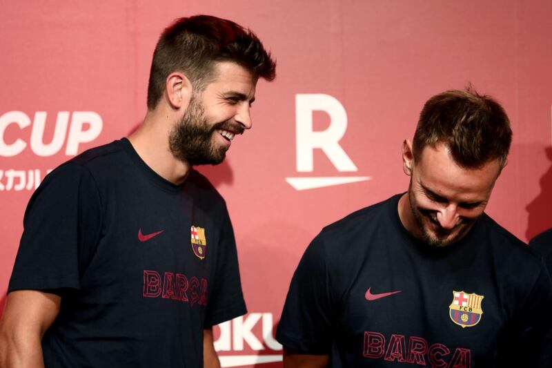 Barcelona's Spanish defender Gerard Pique, left, shares a laugh with  teammate Ivan Rakitic. AFP