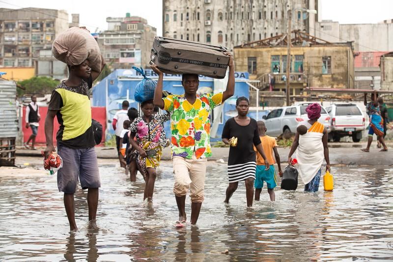People carry their personal effects through a flooded section of Praia Nova, Beira, Mozambique. IFRC/EPA