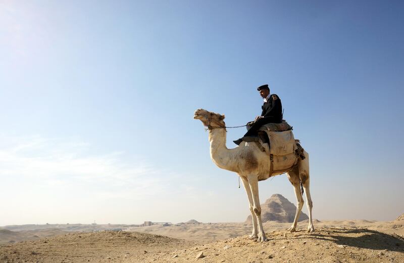 A policeman patrols on a camel at the historical site of the Saqqara, in Giza, Egypt, where a 4,400 year old tomb has been unearthed. AP Photo