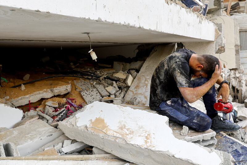 A rescuer reacts as he works with others to remove Palestinian casualties from under the rubble of a house destroyed in Israeli strikes, in Rafah in the southern Gaza Strip. Reuters
