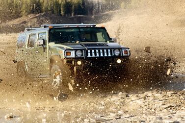 A Hummer SUV charges through the rough terrain of Northern Alberta in 2005, sending debris flying in all directions. Getty Images