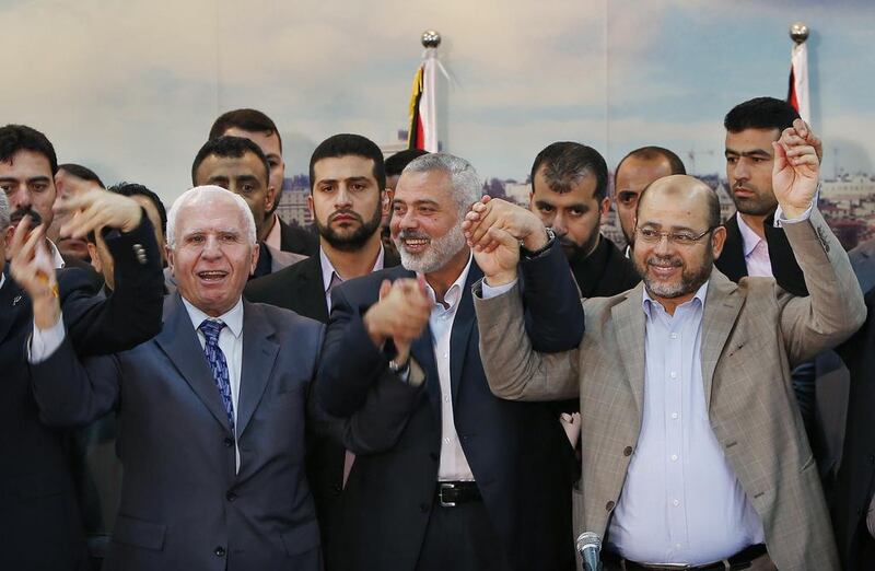 Senior Fatah official Azzam Al Ahmed (L), head of the Hamas government Ismail Haniyeh (C) and senior Hamas leader Moussa Abu Marzouq hold their hands after announcing a reconciliation agreement in Gaza City on April 23. Suhaib Salem / Reuters