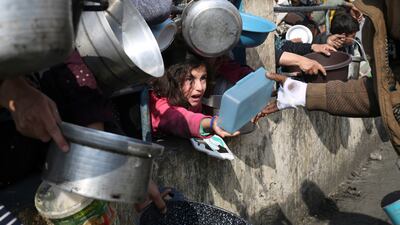 Palestinians line up for food during the Israeli air and ground offensive in Gaza. AP Photo 