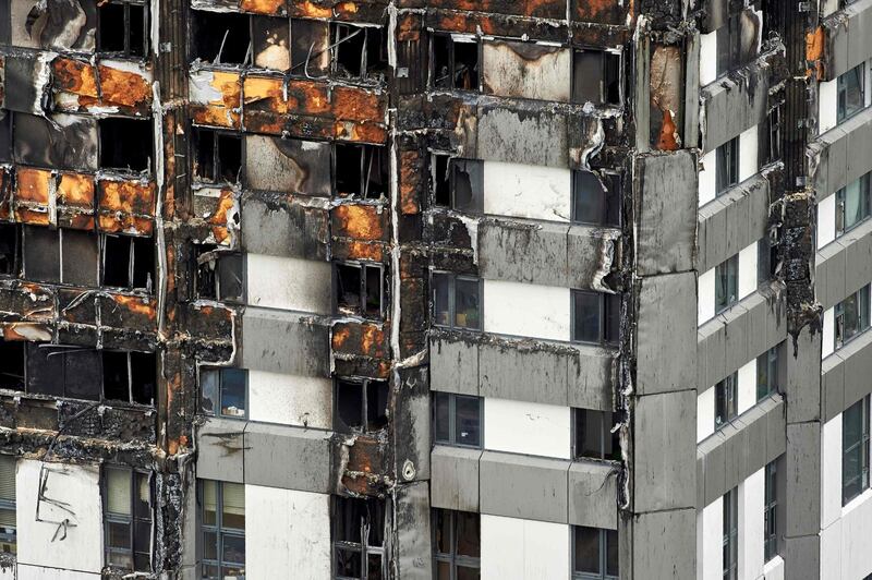 (FILES) In this file photo taken on June 22, 2017, the unburned lower floors with untouched cladding still in place are pictured, with the burnt out upper floors above, at remains of the Grenfell Tower block in north Kensington, west London. Cladding on London's Grenfell Tower was not tested in fire conditions and did not comply with building-safety guidance, according to an expert's report released on June 4, 2018, into the 2017 inferno that killed 71 people. The cladding system and other safety failures meant the policy of telling residents to "stay put" had "effectively failed" within half an hour of the blaze's outbreak, yet remained in place for nearly two hours, fire safety engineer Barbara Lane concluded. / AFP / NIKLAS HALLE'N

