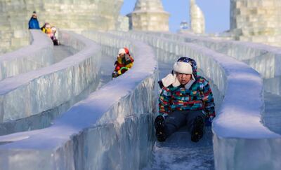 HARBIN, CHINA - JANUARY 16: Children enjoy the ice slides during the 33rd Harbin International Ice and Snow Festival at Harbin Ice And Snow World in Harbin, China on January 16, 2017. The Festival, established in 1985, is held annually on January 5 and lasts over a month.
 (Photo by Zhong Zhenbin/Anadolu Agency/Getty Images)