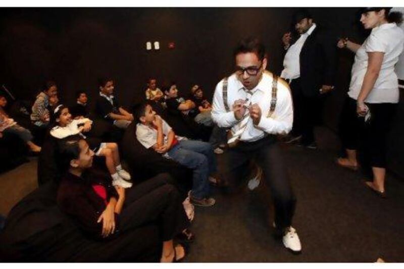 Salman Qureshi, portraying Professor Stanolio, leads his fellow actors Ali al Sayed and Mina Liccianne in a skit prior to a film showing for children in Sharjah.