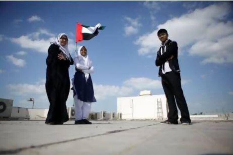 From left: Roksana Akther, 18, Afifa Kochi, 18, and Iqbal Mahmood, 17, stand on the roof of their school. Sammy Dallal / The National