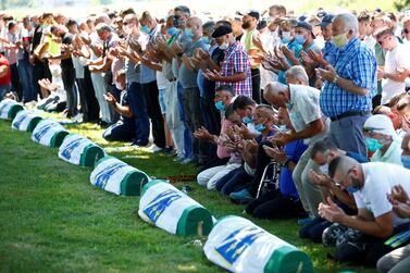 People pray near coffins at a graveyard during a mass funeral in Potocari near Srebrenica. Reuters