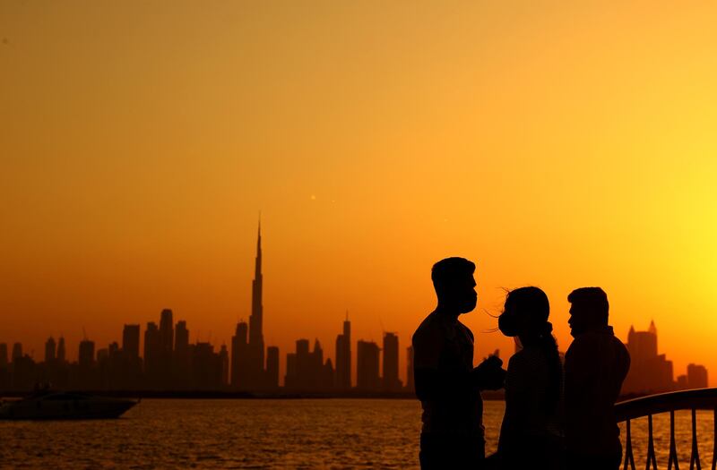People silhouetted against the setting sun in Dubai. Getty
