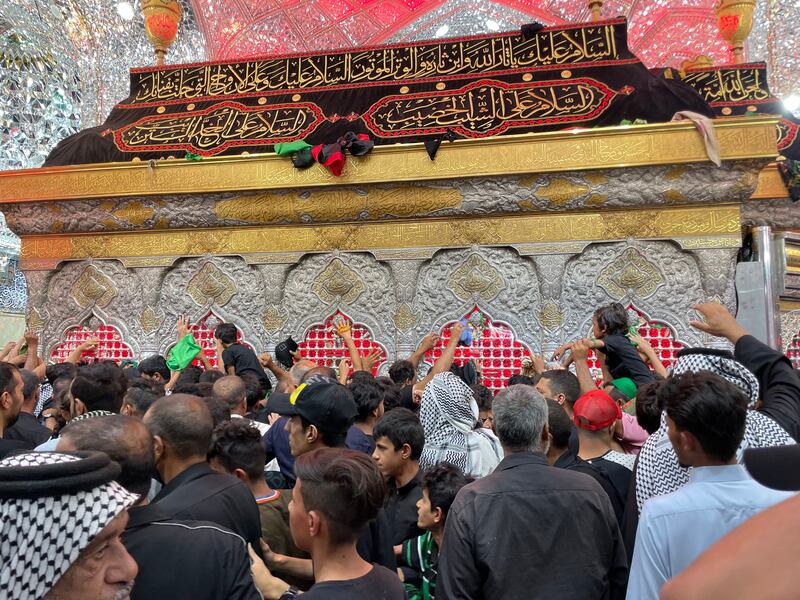 Pilgrims scramble to touch and kiss the protective bars of Imam Hussein's tomb. Sinan Mahmoud / The National