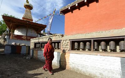 In this photograph taken on June 14, 2016, a Nepalese monk walks past a stupa (chorten) at Ghemi village in Lo Manthang in Upper Mustang.
Deep in the heart of a medieval monastery in Nepal's remote Upper Mustang region, the battle to restore sacred murals and preserve traditional Tibetan Buddhist culture is in full swing. / AFP PHOTO / PRAKASH MATHEMA / To go with 'Nepal-Tibet-Buddhism-Architecture-Painting' FEATURE by Ammu Kannampilly