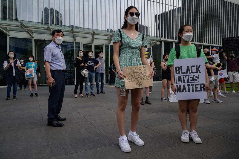 Activists hold placards as they attend a rally in support of the 'Black Lives Matter' protests, during a march in the Myeongdong district of central Seoul on June 6, 2020.   AFP