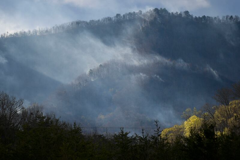 Firefighters from across Tennessee continued working on Thursday morning to contain a wildfire near the Great Smoky Mountains National Park that spread overnight despite rain from storms that passed through the area. Knoxville News Sentinel / AP